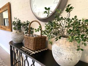 two vases and a basket on a table with plants at The Edward Townhouse 153 - Tastefully Styled in Orange
