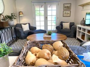 a living room with a table and lots of baskets at The Edward Townhouse 153 - Tastefully Styled in Orange