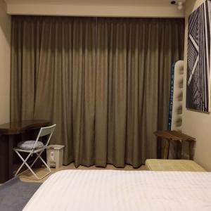 a bedroom with a bed and a desk and a curtain at Luxurious Apartement Lebak Bulus near MRT in Jakarta