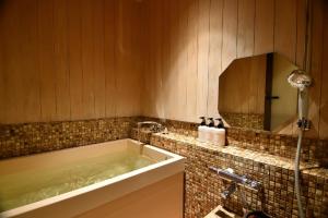 a bathroom with a tub and a sink and a mirror at Yasaka Yutone Kyokoyado in Kyoto +53 photos