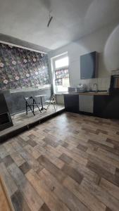 um quarto amplo com piso em madeira e uma cozinha em Pension Winter Obergeschoss em Senftenberg