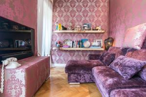 - un salon avec des murs roses, un canapé et une chaise dans l'établissement Rialto Terrace on the Grand Canal, à Venise