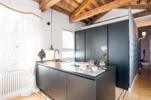 a kitchen with black cabinets and a counter at Rialto Terrace on the Grand Canal in Venice