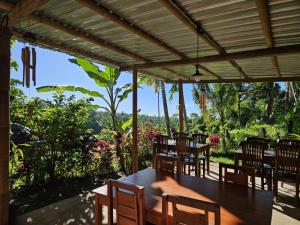 einen Holztisch und Stühle unter einer Pergola in der Unterkunft Tetebatu Fullmoon in Tetebatu + 37 Fotos