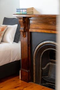 a wooden table with a fireplace next to a bed at Ambrose On Byng - Central Location in Orange
