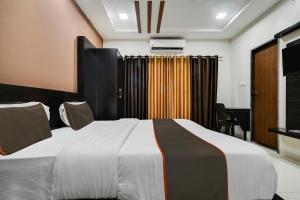 Collection O Santushti Hotel & Restaurant في إندوري: غرفة نوم بسرير كبير في غرفة