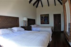 Dos camas en un dormitorio con sábanas blancas. en Exclusive Home Atitlan AT020, en Santa Catarina Palopó 48 fotos más