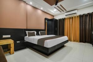 Collection O Santushti Hotel & Restaurant في إندوري: غرفة نوم مع سرير ومكتب وسرير sidx sidx