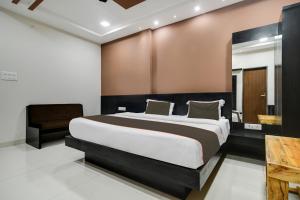 1 dormitorio con 1 cama grande en una habitación en Collection O Santushti Hotel & Restaurant en Indore