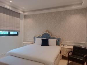 嘉義市的住宿－八拾二弄文旅，一间卧室配有一张带蓝色床头板和椅子的床