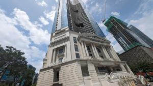 马尼拉EG Private House -BGC UPTOWN的一些建筑物前有一座高塔的建筑