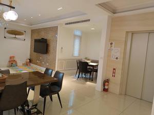 comedor y sala de estar con mesa y sillas en Lane 82 Hostel en Chiayi