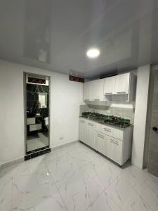 a kitchen with white cabinets and a large mirror at Hotel Las Vegas in Guatapé