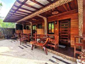 una casa con un patio con mesas y sillas de madera. en Forest wood-Port Barton, en San Vicente
