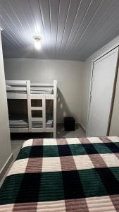 a bedroom with a bed with a checkered blanket at Quitinete ótima localização in Foz do Iguaçu