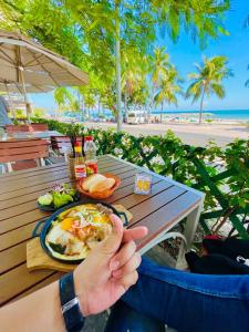 una persona sentada en una mesa con un plato de comida en Sealiks Ocean vita Codotel muine C326, en Phan Thiet