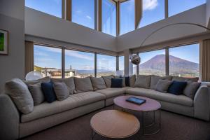 a living room with a large couch and a table at The Maples Niseko in Kutchan +163 photos