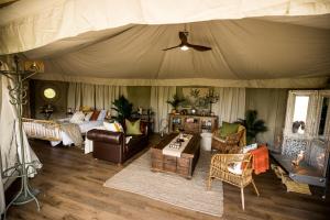 1 dormitorio con 1 tienda de campaña con 1 cama y muebles en Orchard Valley Glamping, en Otorohanga