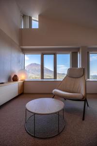 a living room with a chair and a coffee table at The Maples Niseko in Kutchan