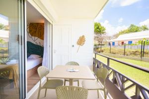 a patio with a table and chairs on a balcony at Studio neuf et cosy proche des plages - L'Alamanda in Le Gosier