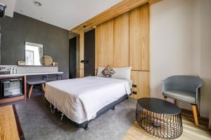 墾丁的住宿－牧海48輕行旅店，一间卧室配有一张床、一张桌子和一把椅子