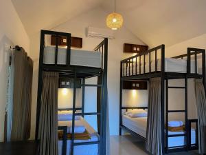 una stanza con tre letti a castello in una stanza di Mayong Bali Villa and Hostel a Munduk