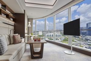 a living room with a couch and a flat screen tv at Shangri-La Qiantan, Shanghai in Shanghai