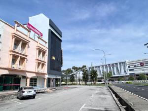 an empty street in front of a pink building at BEAR HOTEL at NILAI in Nilai