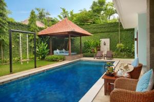 a swimming pool in a backyard with a gazebo at Kecapi Villa Seminyak by Ini Vie Hospitality in Seminyak