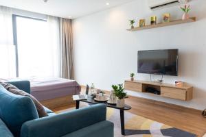 uma sala de estar com um sofá azul e uma televisão em Bon Homestay View biển Hạ Long em Ha Long