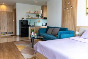 - un salon avec un lit et un canapé bleu dans l'établissement Bon Homestay View biển Hạ Long, à Hạ Long