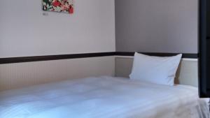 a bed with white sheets and pillows in a room at Toyoko Inn Tokyo Otsuka-eki Kita-guchi No 1 in Tokyo