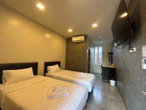 a hotel room with two beds and a flat screen tv at Uthaithani Resort in Uthai Thani