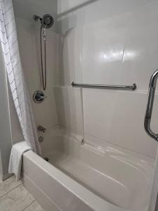 a white bathroom with a shower and a bath tub at Suite and Simple in Ucluelet