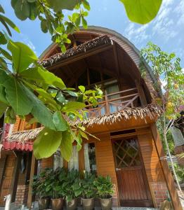 a wooden house with plants in front of it at Golden Chenang Village in Pantai Cenang
