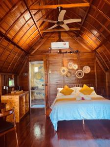 a bedroom with a bed and a ceiling fan at Golden Chenang Village in Pantai Cenang