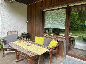 una mesa de madera y sillas en un patio en Ferienapartments Engeln Eifel, en Kempenich