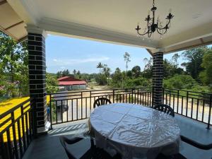 a table on a balcony with a view of a river at Teratak Khalisa in Tanah Merah