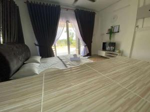 a bedroom with a large bed and a window at Teratak Khalisa in Tanah Merah