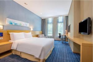 a hotel room with a large bed and a television at Holiday Inn Express Beijing Airport Zone by IHG in Beijing
