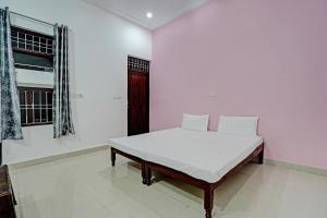 una camera bianca con un letto in una stanza di OYO Parth Logistics a Rewāri