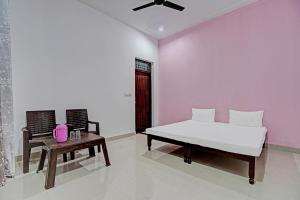 una camera con letto, tavolo e sedia di OYO Parth Logistics a Rewāri