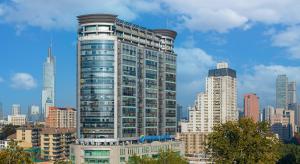 een hoog gebouw met veel ramen in een stad bij Suning Universal Hotel ALL-SUITES in Nanjing