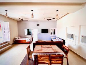 sala de estar con mesa y sofá en Gooseberry Garden en Ayodhya