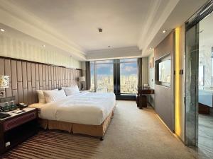 Postel nebo postele na pokoji v ubytování Suning Universal Hotel ALL-SUITES