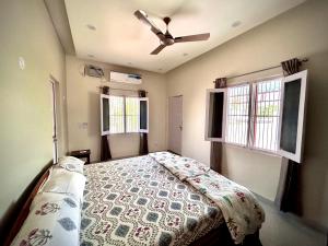 een slaapkamer met een bed en een plafondventilator bij Gooseberry Garden in Ayodhya
