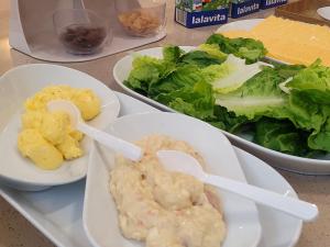 a table topped with plates of food with dip and salad at Hound Hotel Gijang Osiria in Busan