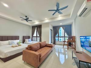 a bedroom with a bed and a couch and a tv at Bali Sea View Residences Melaka at Stayrene in Melaka