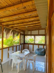 eine Veranda mit einem Tisch und Stühlen auf einer Veranda in der Unterkunft Fundo El Cortarrama in Talara