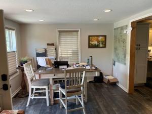 Habitación con escritorio con sillas y ordenador. en Creekside cottage, en Owatonna